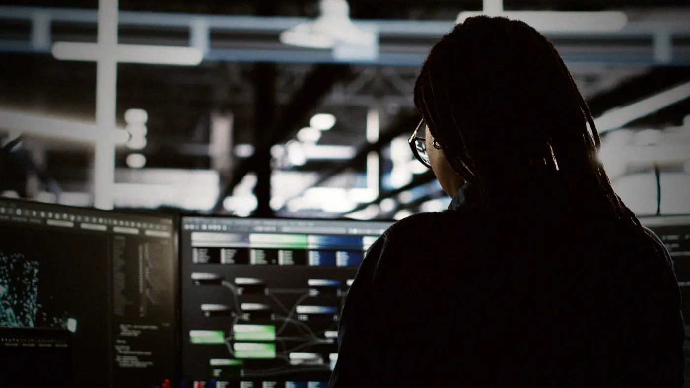 A data centre administrator works a console at night, in front of the monitoring and detection an adversary simulation is designed to test.